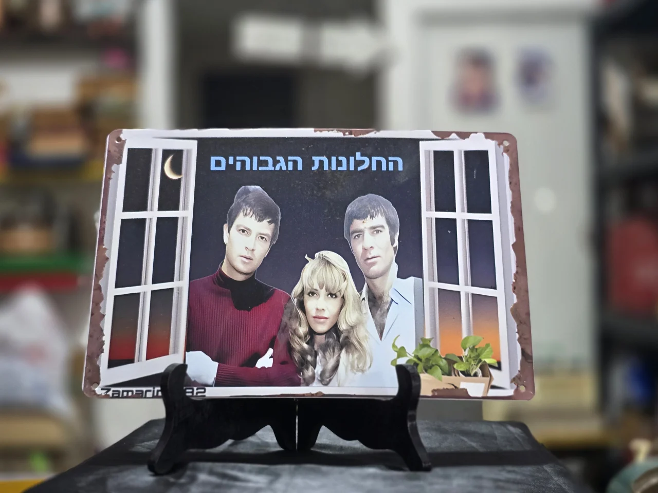 החלונות הגבוהים שלט פח לתלייה על הקיר - אריק איינשטיין, ג'וזי כץ ושמוליק קראוס.  מידות - 30.0X20.0 סמ.  חתום - Zamarin 1882  מצב כחדש.