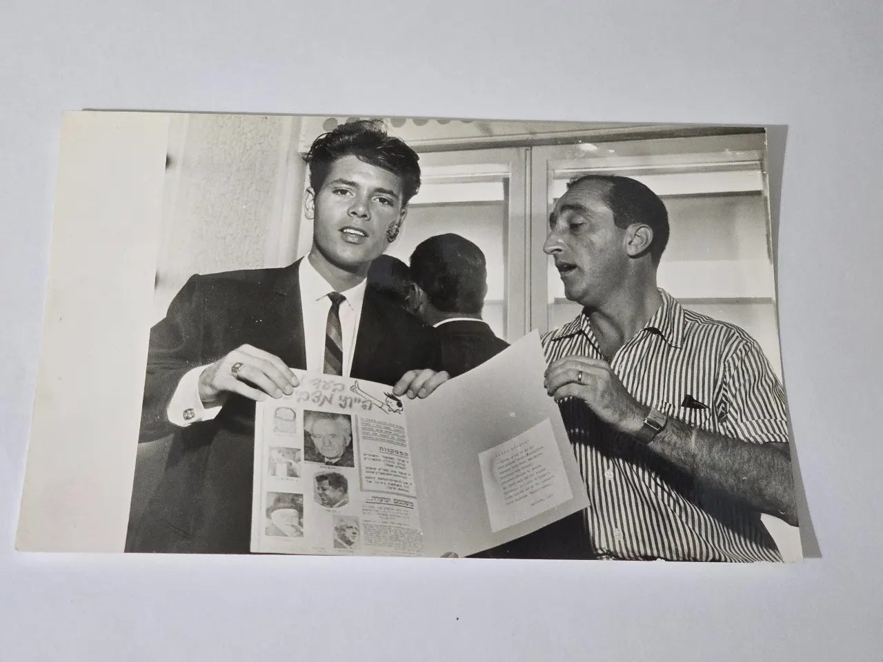 תצלום של הזמר קליף ריצ'רד בביקורו בישראל ב-1963, בחברת המפיק גיורא גודיק. תצלום חתום: נחום גוטמן מידות: 18 ס"מ * 12 ס"מ