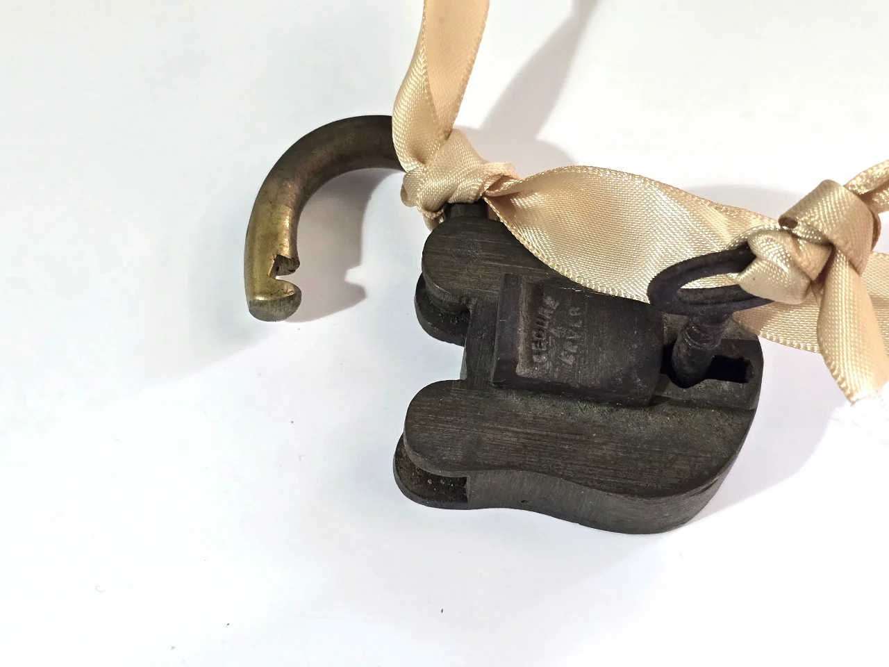 מנעול תליה עתיק עשוי פליז בעל מנגנון מכני על המנעול כתוב SECURE 4 LEVER המספר 4 מציין את מספר המנופים בתוך המנעול