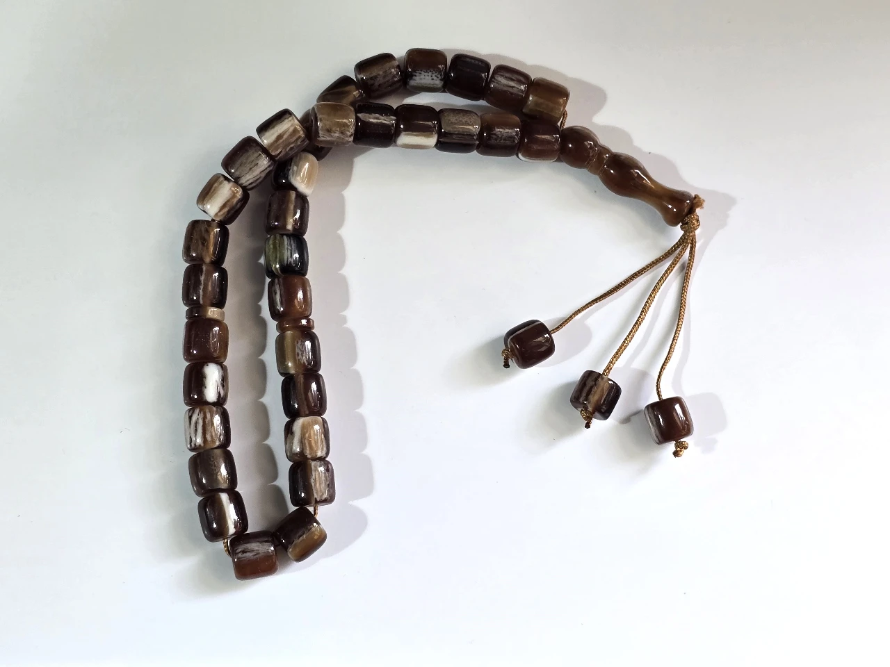 Tesbih מחרוזת תפילה איסלאמית מסבחה, טסביה, 33 חרוזי תפילה מסורתיים קלאסיים, עם מפרידים, מסתיימת ב"אימאם" (החלק המאורך בקצה) ו 3 חרוזים קינטיים.  טסביח מחרוזת תפילה, מסבחה איסלמית, בעיצוב מסורתי, עם דיסקיות הפרדה כל 11 חרוזים.   החרוזים עשויים דמוי אגת.  אורך כללי 32 ס"מ.  מצב מושלם.