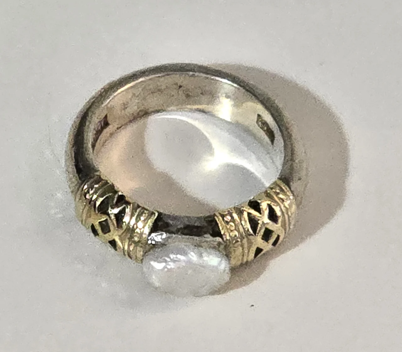 טבעת כסף 925 חתומה במרכזה פנינה לבנה ובצידי האבן נגיעות של זהב וינטג' יפה ואיכותית. מידה: 6 משקל: 8 גרם