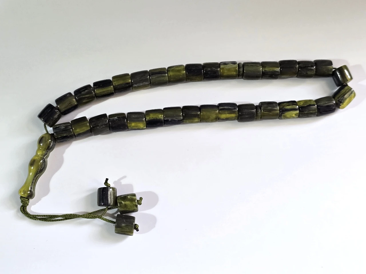 Tesbih מחרוזת תפילה איסלאמית מסבחה, טסביה, 33 חרוזי תפילה מסורתיים קלאסיים, עם מפרידים, מסתיימת ב"אימאם" (החלק המאורך בקצה) ו 3 חרוזים קינטיים. טסביח מחרוזת תפילה, מסבחה איסלמית, בעיצוב מסורתי, עם דיסקיות הפרדה כל 11 חרוזים. החרוזים עשויים דמוי אוניקס. אורך כללי 32 ס"מ. מצב מושלם.