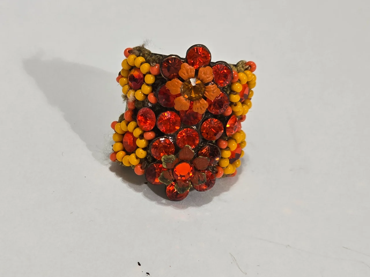 טבעת גדולה ומרשימה מבית מיכל נגרין חתומה מאחור הטבעת מתכווננת בצבעים אדום צהוב אבני סברובסקי