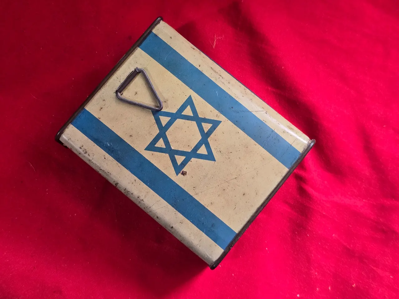 קופת צדקה - קרן קיימת לישראל    איור של מפת ישראל עם ציון של הערים הגדולות ודגל ישראל  14*9 סמ' תוצרת אלברט זלצמן ירושלים היחודי בקופה זו שעקבה מופיעה על המפה קופסה זו משנות ה.40\50