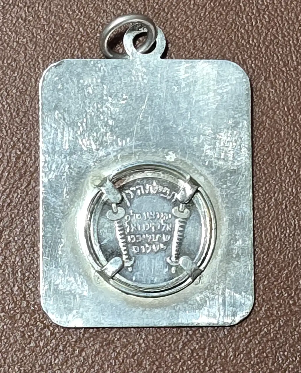 תליון כסף מלבני, בצירוף הכיתוב בחלקו הקדמי: שמע ישראל ובחלקו האחורי: תפילת הדרך.  חתום 925.  משקל: 4.20 גרם.  אורך: 3 ס'מ.