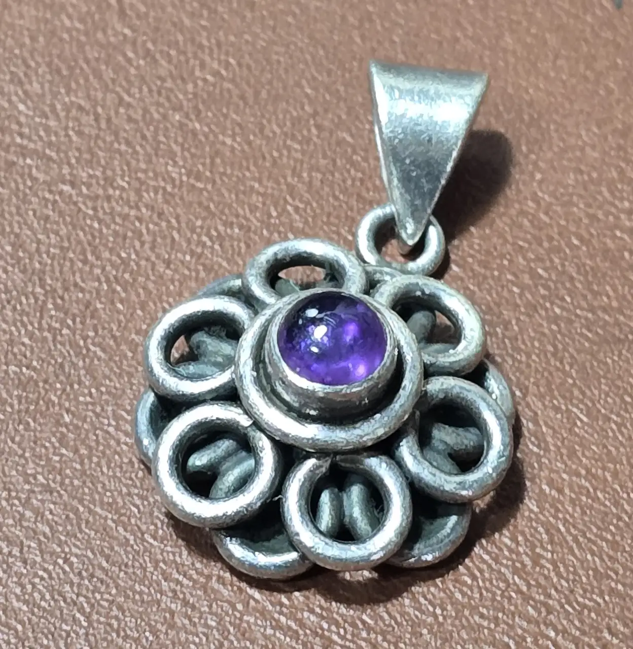 תליון כסף בדוגמת פרח משובץ אבן אמטיסט.  חתום 925.  משקל: 8 גרם.  אורך: 3 ס'מ.
