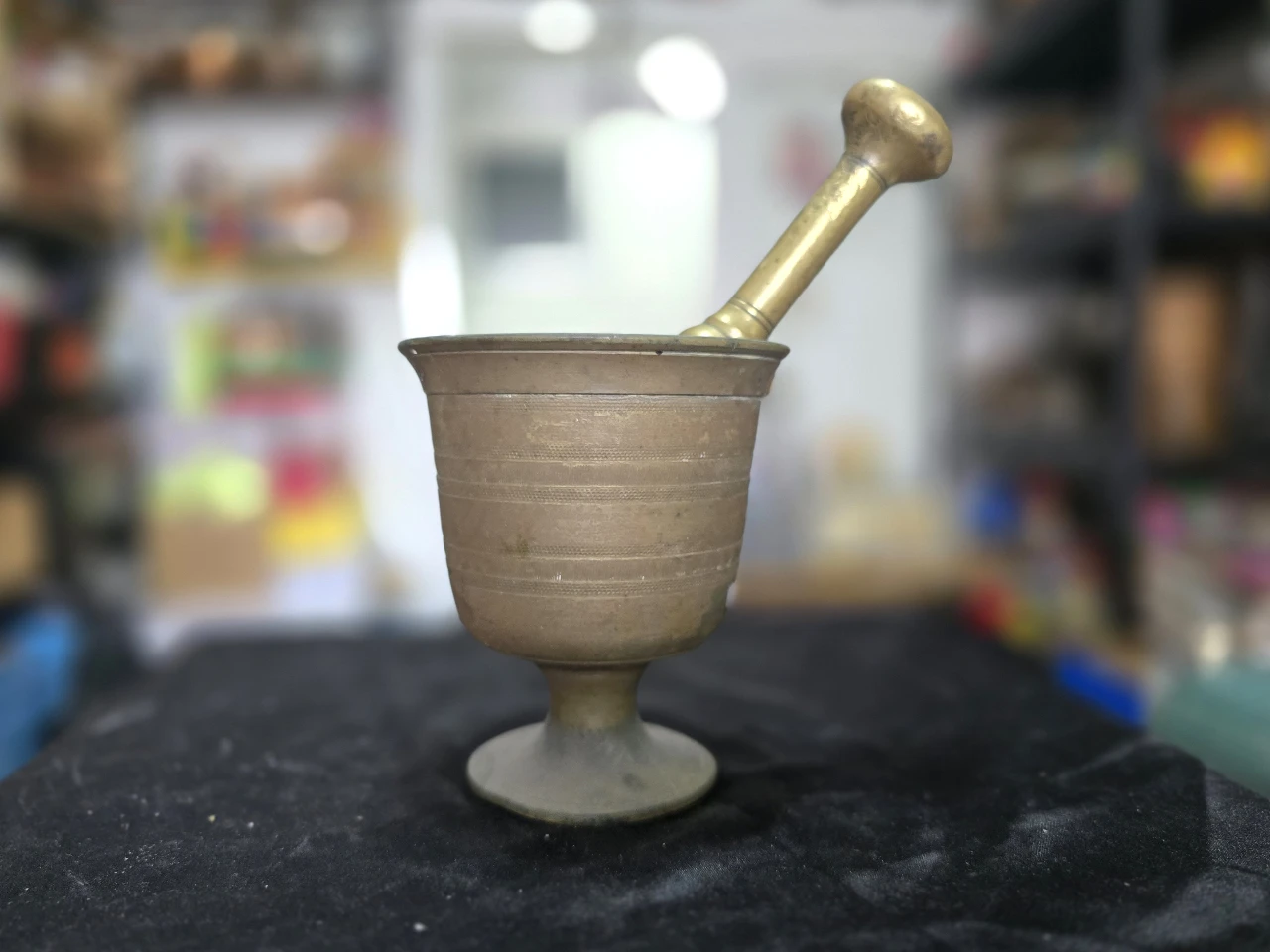 תאור הפריט: מכתש ועלי מברונזה עתיקים, מעוטר בשתי טבעות חישוקים מסביבו, גובה: 12 ס"מ, קוטר: 11.5 ס"מ.