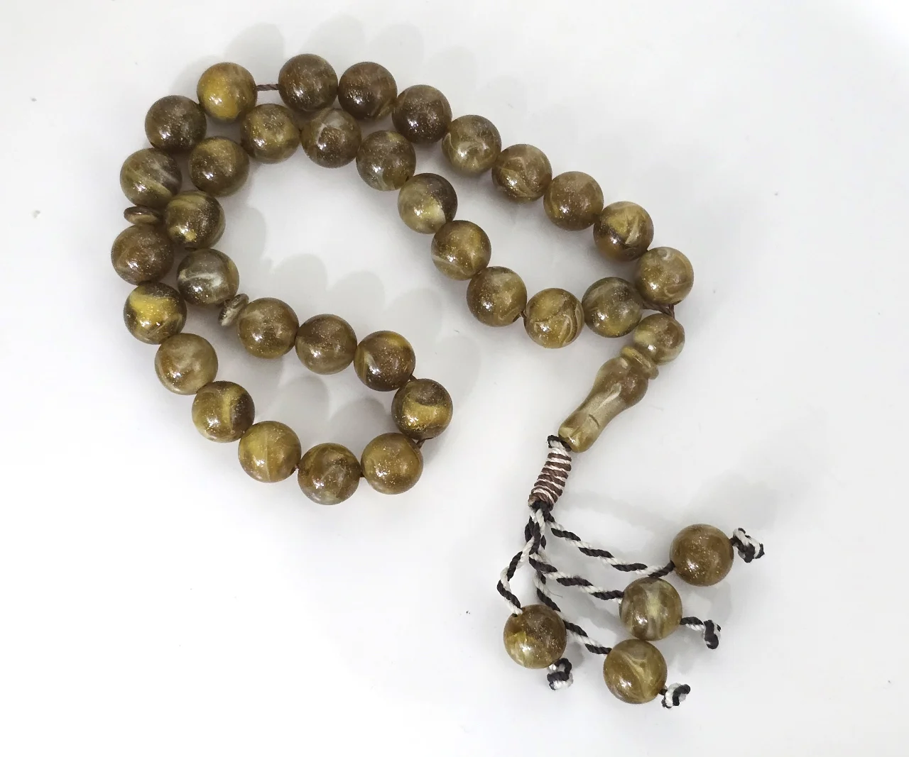 מאסבחה מרשימה. חרוזי זכוכית ירקרקה ותתי גוונים. מספר החרוזים - 33, עם אימאם ומפרידים וכן ארבעה חרוזי תליונים בקצה המאסבחה.