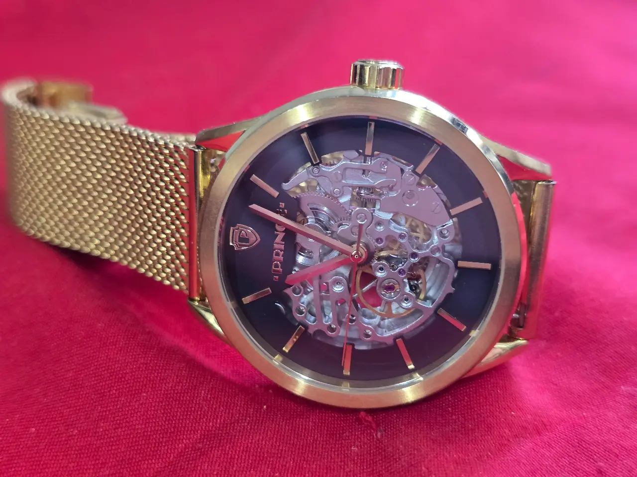 שעון יד לגבר עם מנגנון אוטומתי עם תנועת היד .ניתן לראות את גלגלי השינים של השעוןגוף השעון והרצועות בגוון זהב