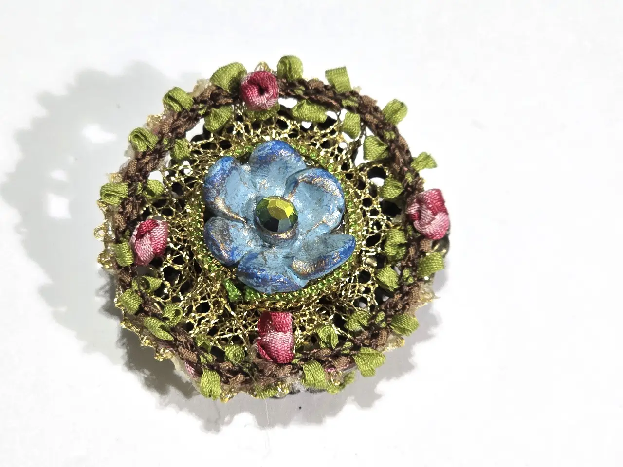 סיכה נדירה של מיכל נגרין חתומה מאחור שזור בחוטי זהב שבתוכם ורדים ובמאכז פרח כחול עם אבן סברובסקי ירוקה
