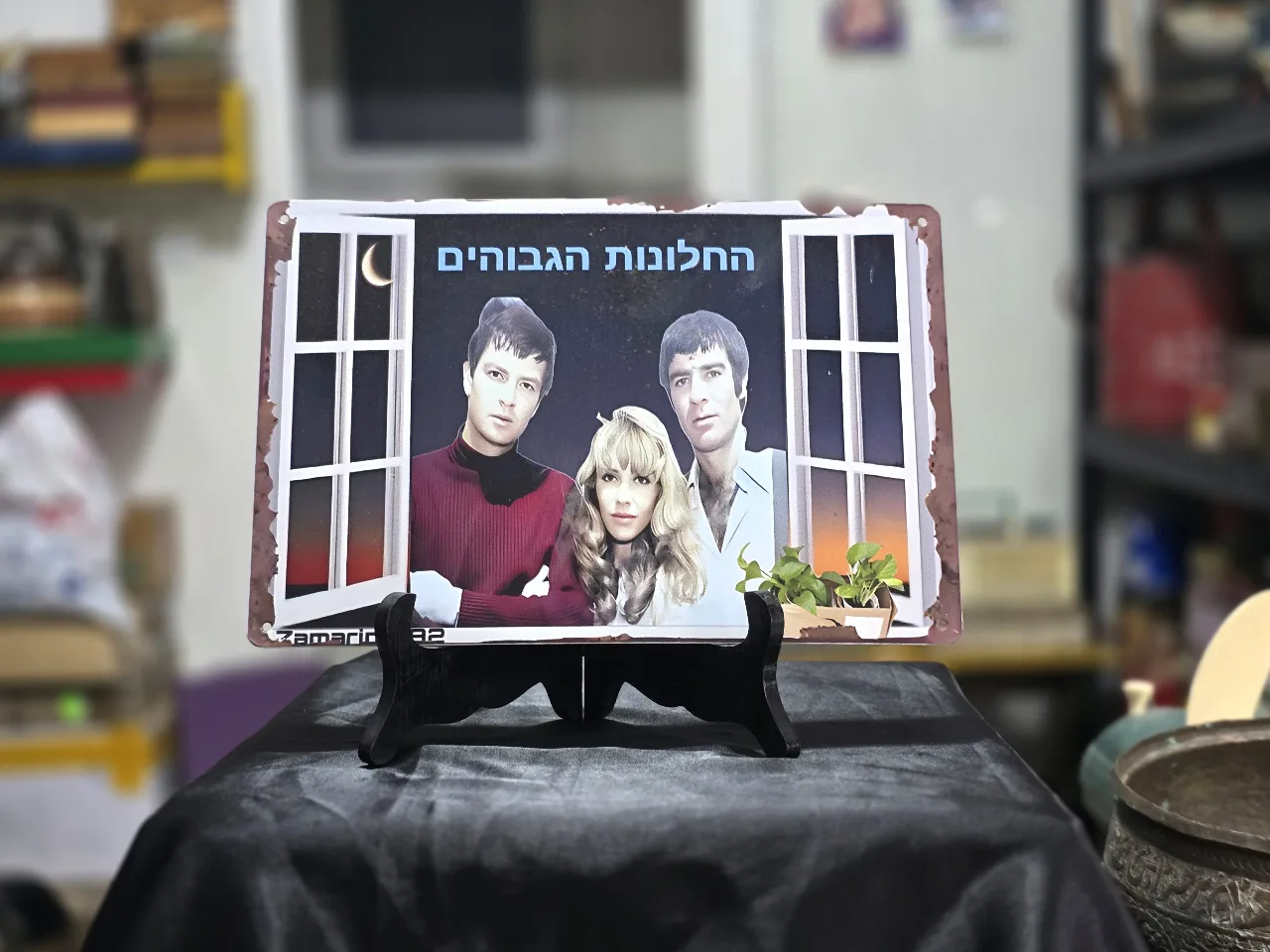 החלונות הגבוהים שלט פח לתלייה על הקיר - אריק איינשטיין, ג'וזי כץ ושמוליק קראוס.  מידות - 30.0X20.0 סמ.  חתום - Zamarin 1882  מצב כחדש.