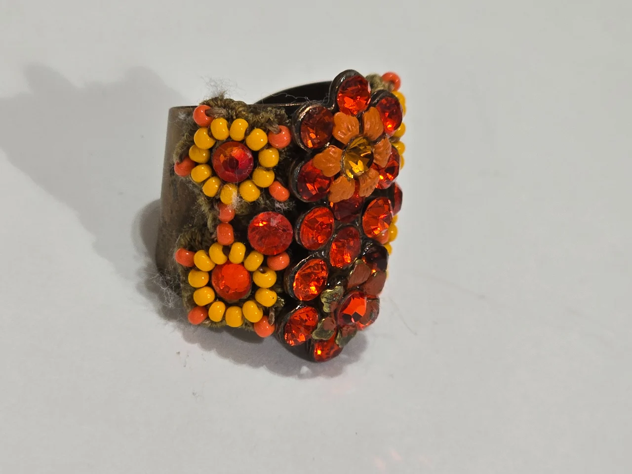 טבעת גדולה ומרשימה מבית מיכל נגרין חתומה מאחור הטבעת מתכווננת בצבעים אדום צהוב אבני סברובסקי