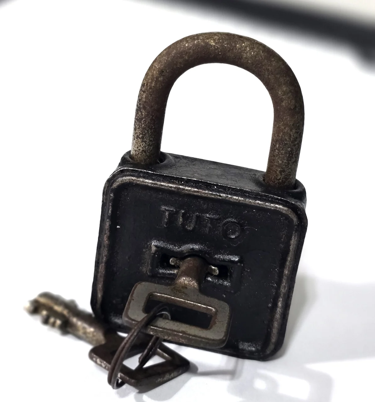 מנעול עתיק ממתכת, חתום TUTO, עם המפתח המקורי. מצב שימושי עם פטינה של הזמן. מידות: ‎8 × 4 × 2 ס”מ