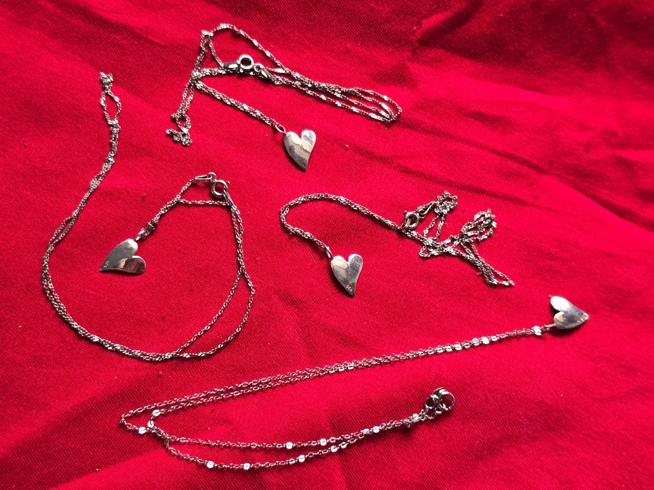 לוט של 4 שרשראות כסף מעוטרות בתליון בדמות לב.  חתומים.  אורך השרשרת 45.5 ס'מ.  משקל כולל 6.8 גרם.