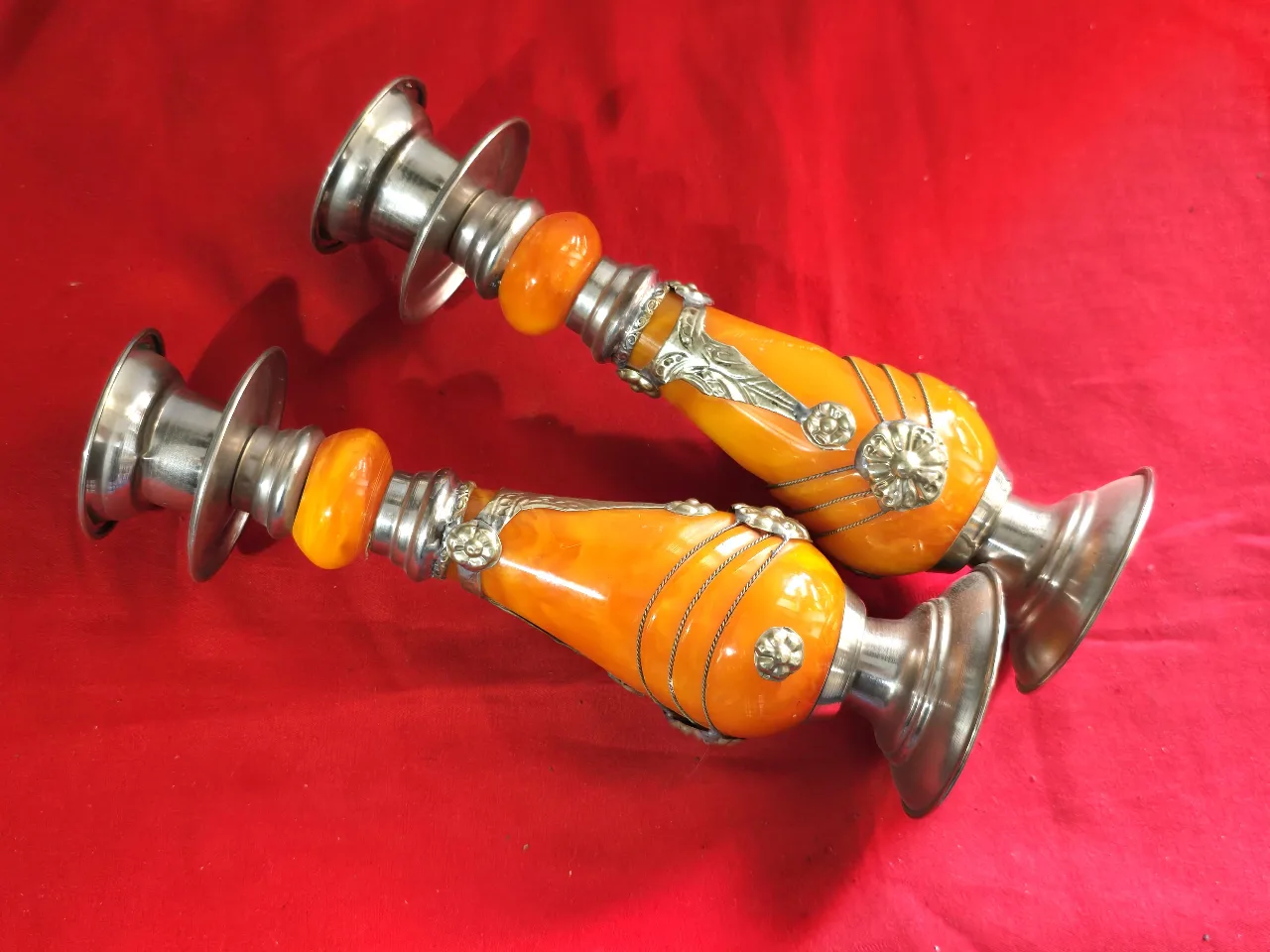 זוג פמוטי שבת מרוקאיםי, עשויים זכוכית בצבע ענבר ופיוטר(ייתכן חומר שרף כלשהו, לא נבדק לעומק), עבודת יד.   מעוטר בקישוטי מתכת וחוטי מתכת דקים כרוכים סביב הפמוטים.