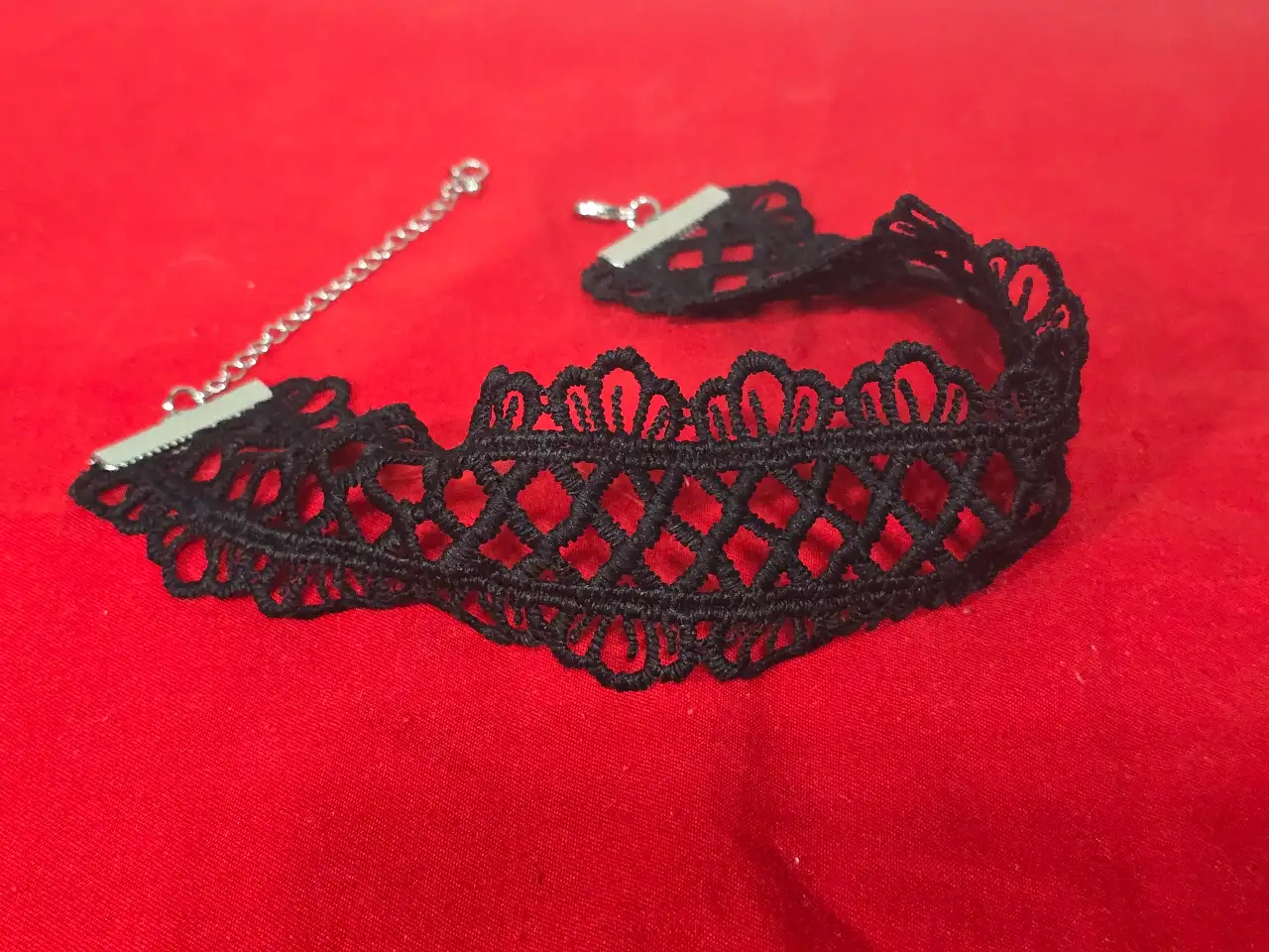 זוג שרשראות צ'וקר צמודות לצוואר שנהם מתחרה סגנון ויקטוריאני או גותי השרשרת הלבנה עשויה מתחרה לבנה בדוגמא גאומטרית שבחלק התחתון פנינים קטנות על גבי לולאות מתכת דקיקות התליון המרכזי משובץ בפנינה גדולה מעוטרת בהברונזה הצו'קר השחור מתחרה בדוגמת רשת עם סוגר ושרשרת הארכה כסוף