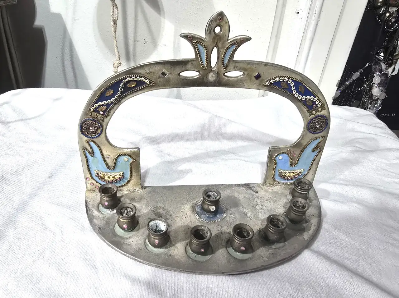 חנוכיה מעוצבת ע'י המעצבת אסתר חתום בתחתית החנוכיה עשויה ככתר שילובי אמייל וזרקונים קטנים