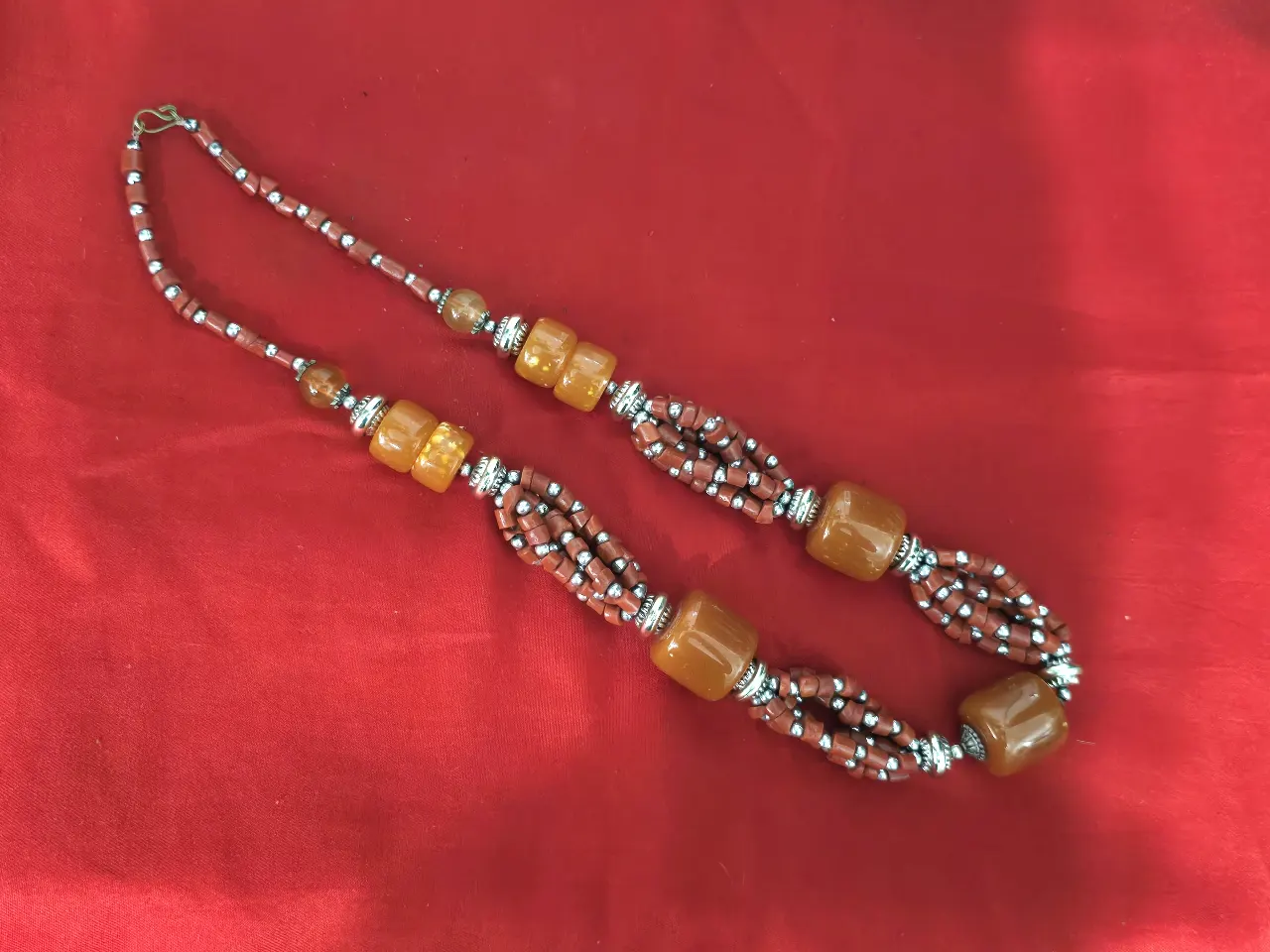 שרשרת עם חרוזים גדולים בצבע ענבר וחרוזים קטנים יותר בנהם שרשרת צבעונית יפה ומרשימה