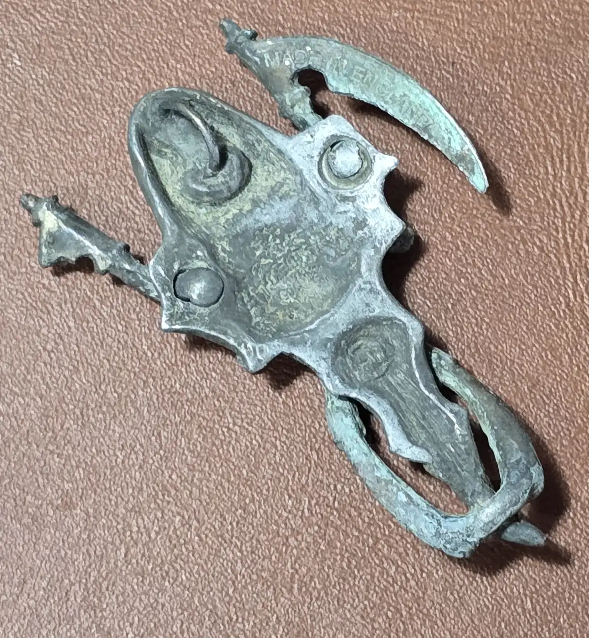 תליון מראה דמות נשית מביטה אל תוך המראה עשוי מפיוטר והדמות השניה מלאך המוות