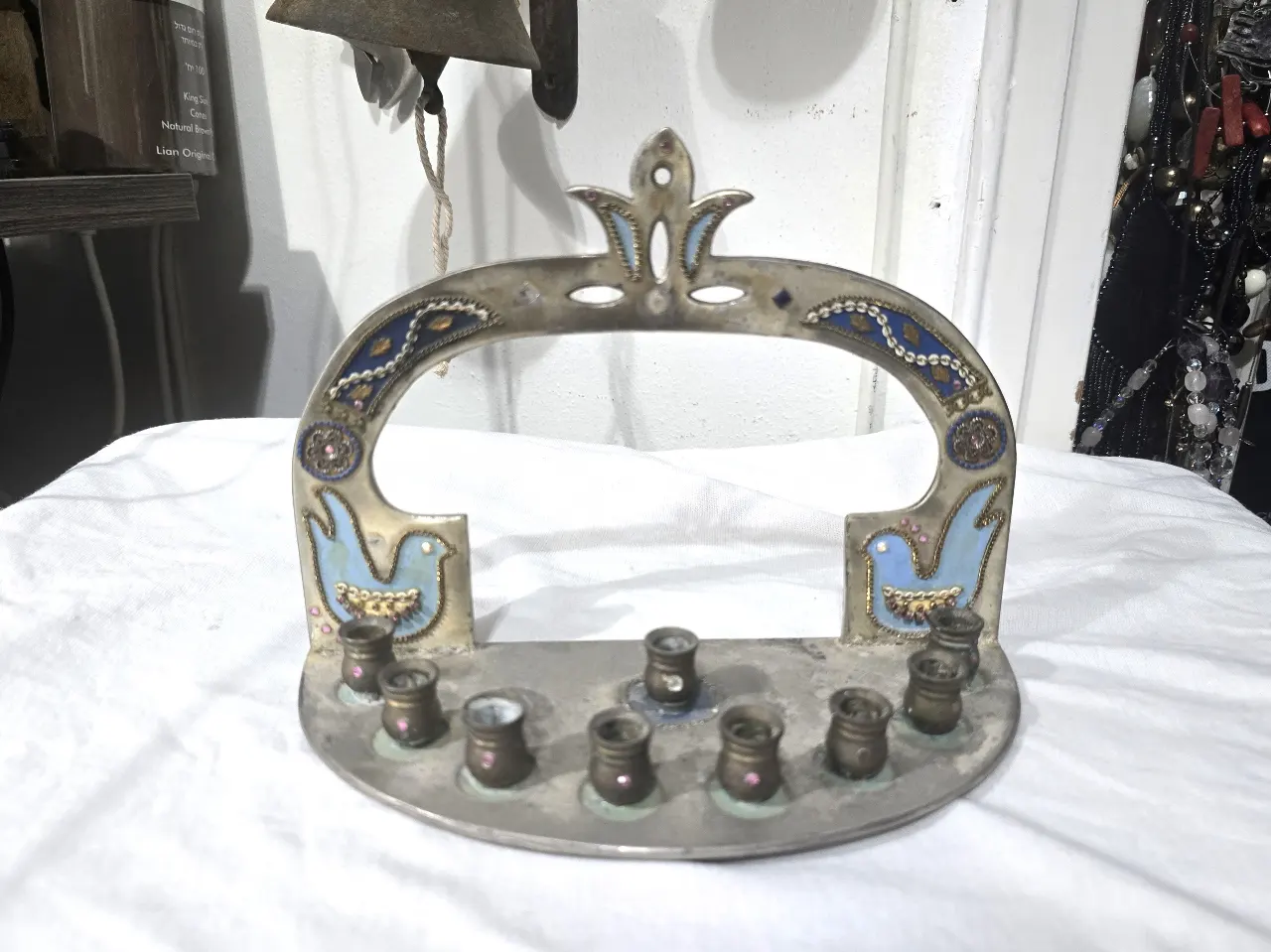 חנוכיה מעוצבת ע'י המעצבת אסתר חתום בתחתית החנוכיה עשויה ככתר שילובי אמייל וזרקונים קטנים