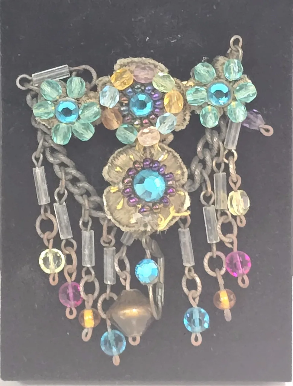 סיכה שהיא פריט אספנות סגנון וינט'ג הסיכה משובצת בחרוזים צבעוניים  הכוללת אלמנטים בצורת פרחים