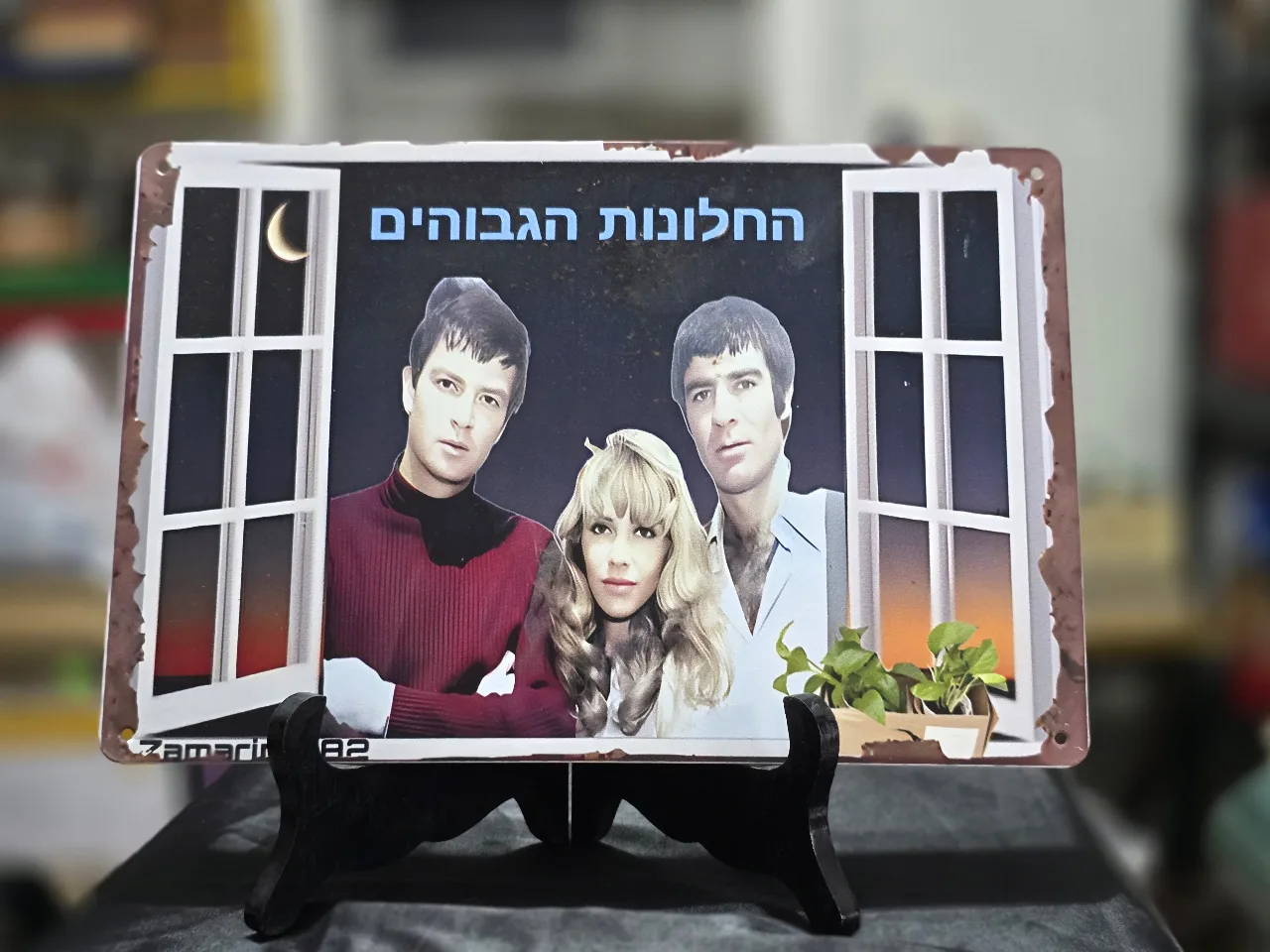 החלונות הגבוהים שלט פח לתלייה על הקיר - אריק איינשטיין, ג'וזי כץ ושמוליק קראוס.  מידות - 30.0X20.0 סמ.  חתום - Zamarin 1882  מצב כחדש.