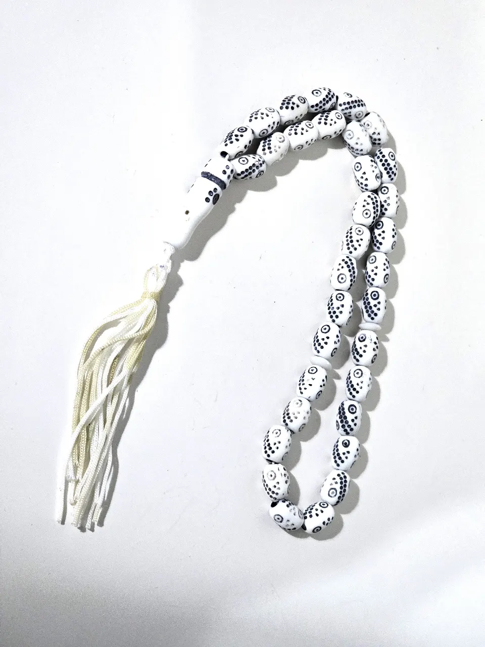 מסבחה מחרוזת תפילה בעיצוב יחודי עם חרוזים לבנים ועלהם דפוסים שחורים קטנים המחרוזת כוללת 33 חרוזים