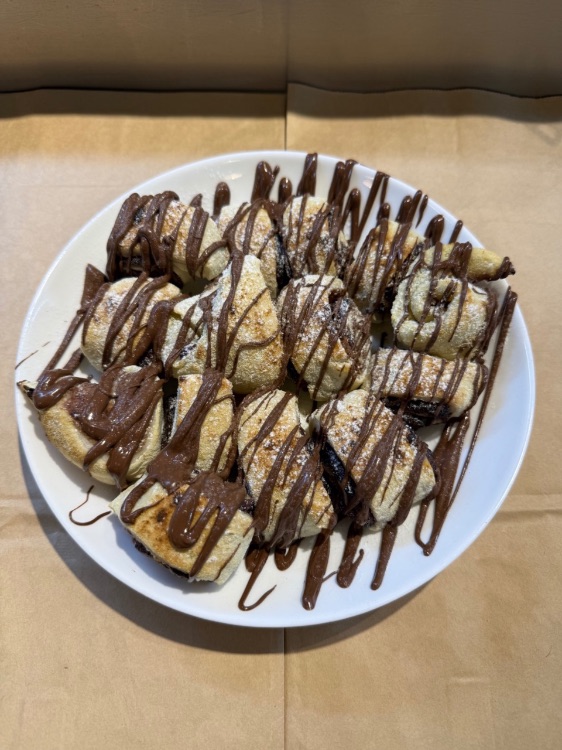 רוזלך נוטלה - בצק מגולגל בנוטלה, בזילופי שוקולד לבן נוטלה ואבקת סוכר.