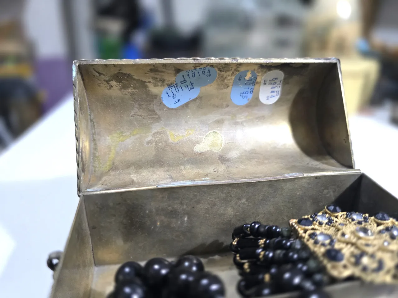 קופסת תכשיטים ממתכת (פליז) בצורת תיבה למעלה במיכסה משובצת אבן חן בתוך התיבה ישנה שרשרת אופנתית התיבה ישנה מאד יש בולי הכנסה מידות 13\6\8 ס'מ