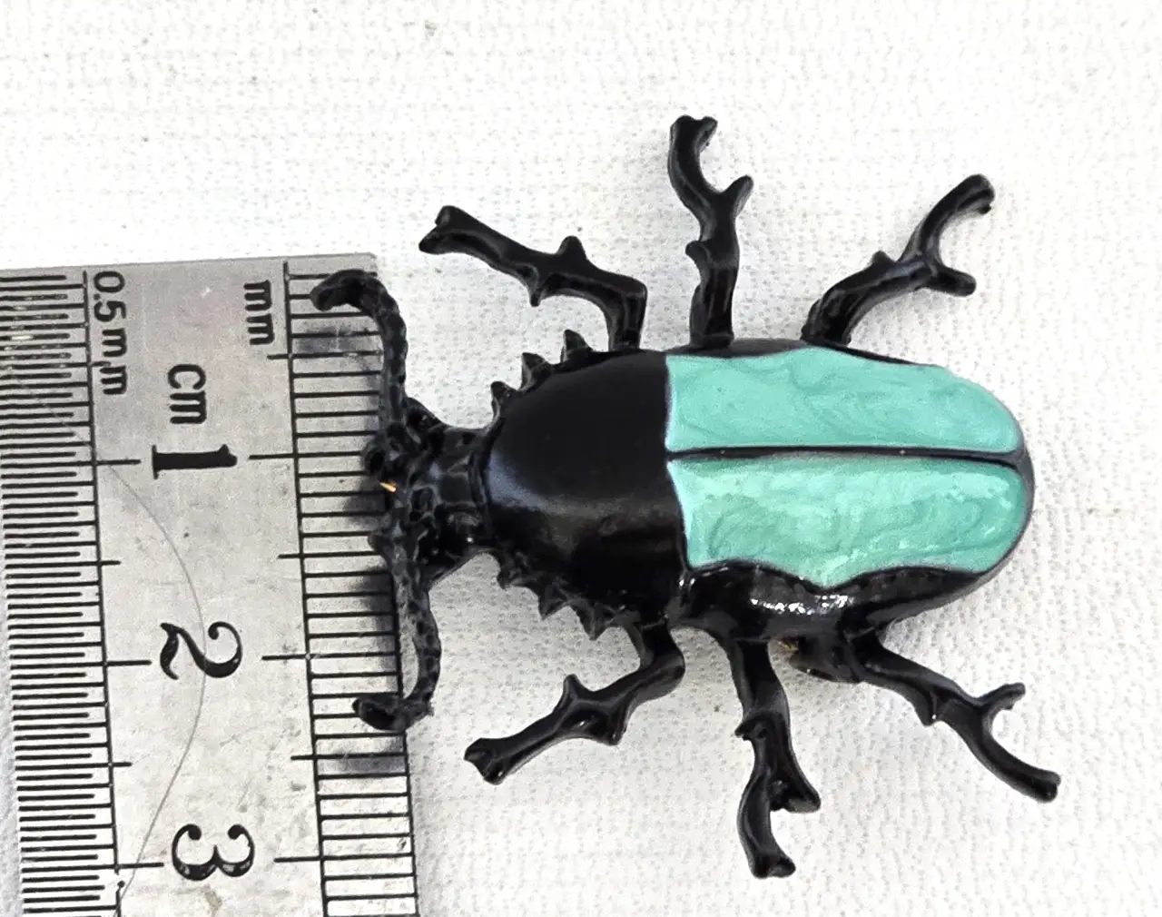 סיכת חרפושית - מתכת שחורה עם גב סברובסקי בצבע טורקיז אורך 3.5 ס"מ