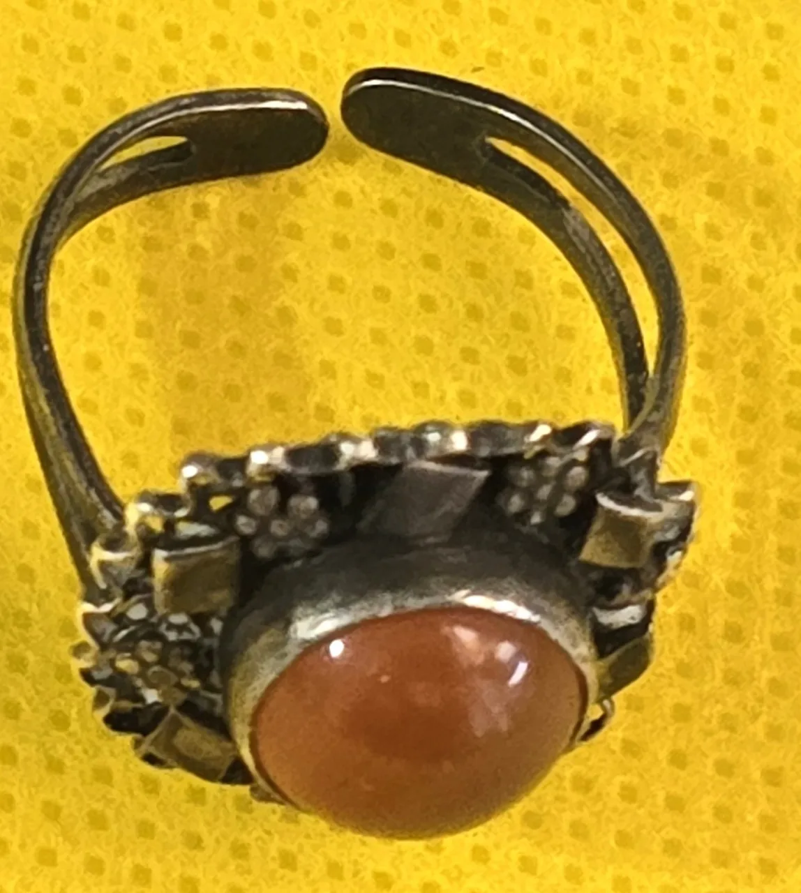 טבעת כסף עדינה ויפה, משובצת אבן אגת ומעוטרת מסביב בדוגמאות פרחים ומעוינים קטנים.  לא נמצאה חתימה.  מידת הטבעת: מתכווננת  משקל: 4.18 גרם.