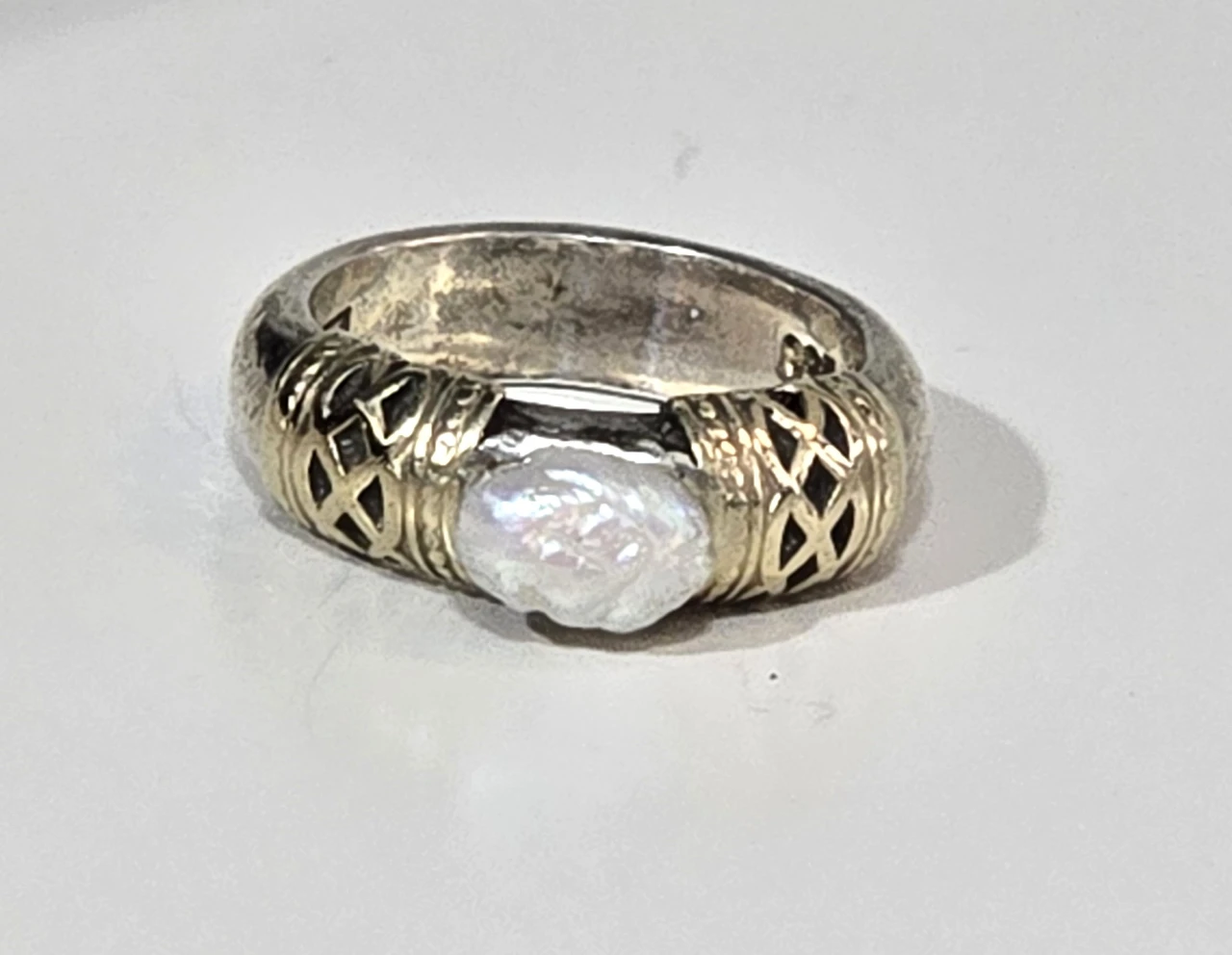 טבעת כסף 925 חתומה במרכזה פנינה לבנה ובצידי האבן נגיעות של זהב וינטג' יפה ואיכותית. מידה: 6 משקל: 8 גרם