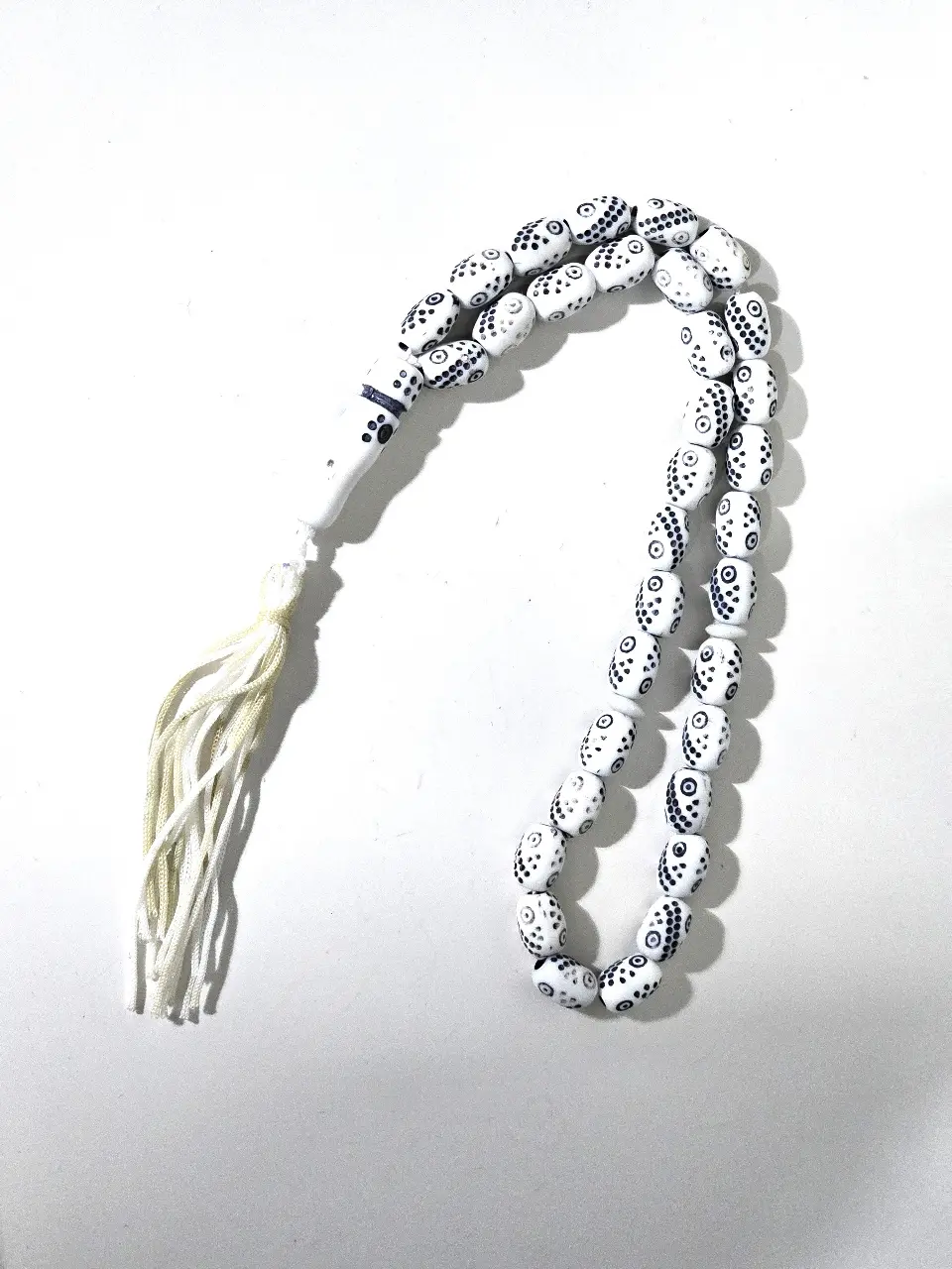 מסבחה מחרוזת תפילה בעיצוב יחודי עם חרוזים לבנים ועלהם דפוסים שחורים קטנים המחרוזת כוללת 33 חרוזים