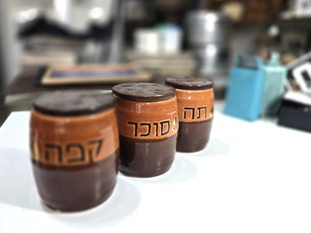 סט 3 מיכלי קרמיקה לסוכר, קפה ותה, עם מכסים מעץ, מידות 10/13 ס"מ  חתומים בבסיס ונושאים את מדבקת היצרן, בן פורת,  לא היו בשימוש.