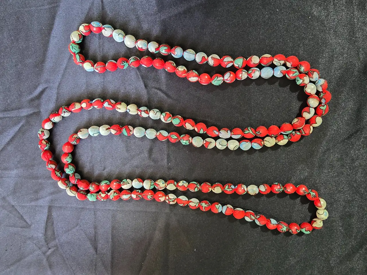 שרשרת ארוכה העשויה מחרוזי עץ שנעטפו בבד דק הפריט מעניין