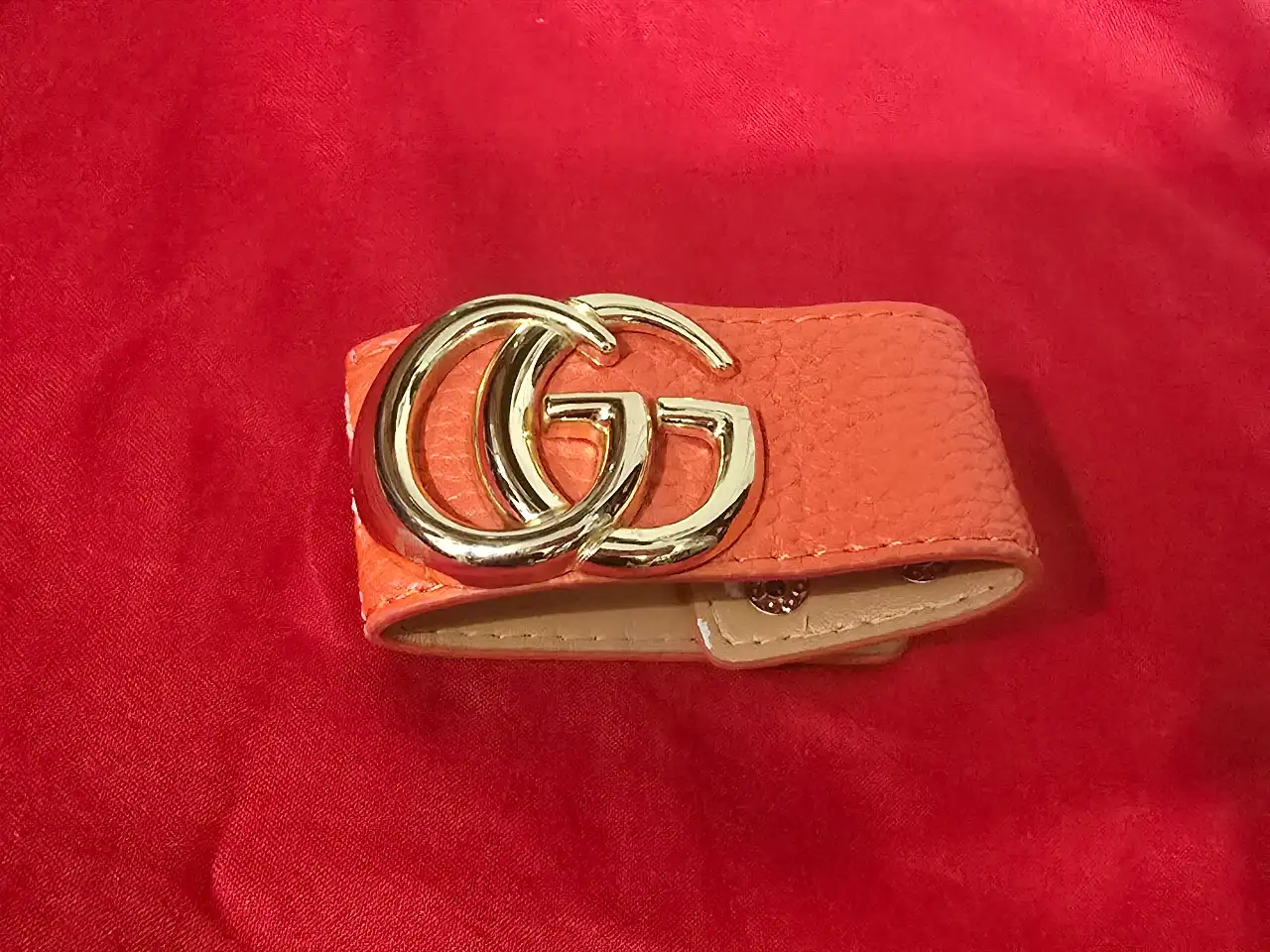 צמיד עור כתום לנשים של המותג (Gucci) מסדרת GG Marmont הכולל אבזם מוזהב בצורת סמל המותג הכפול