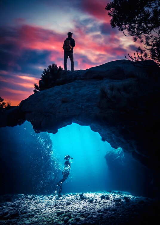 Fotografie de artă Diving under seabed and red clouds