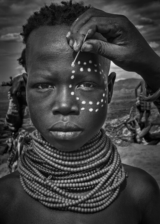 Kunstfotografie Painting the face of a karo tribe girl (Omo Valley-Ethiopia)