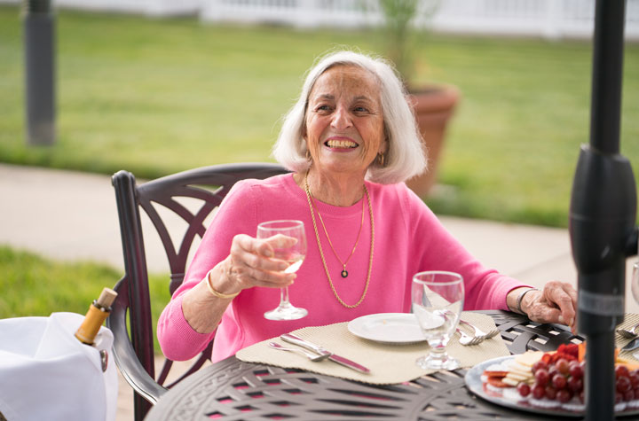 Senior woman drinking wine on patio