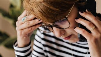 woman worried talking on phone backpayments