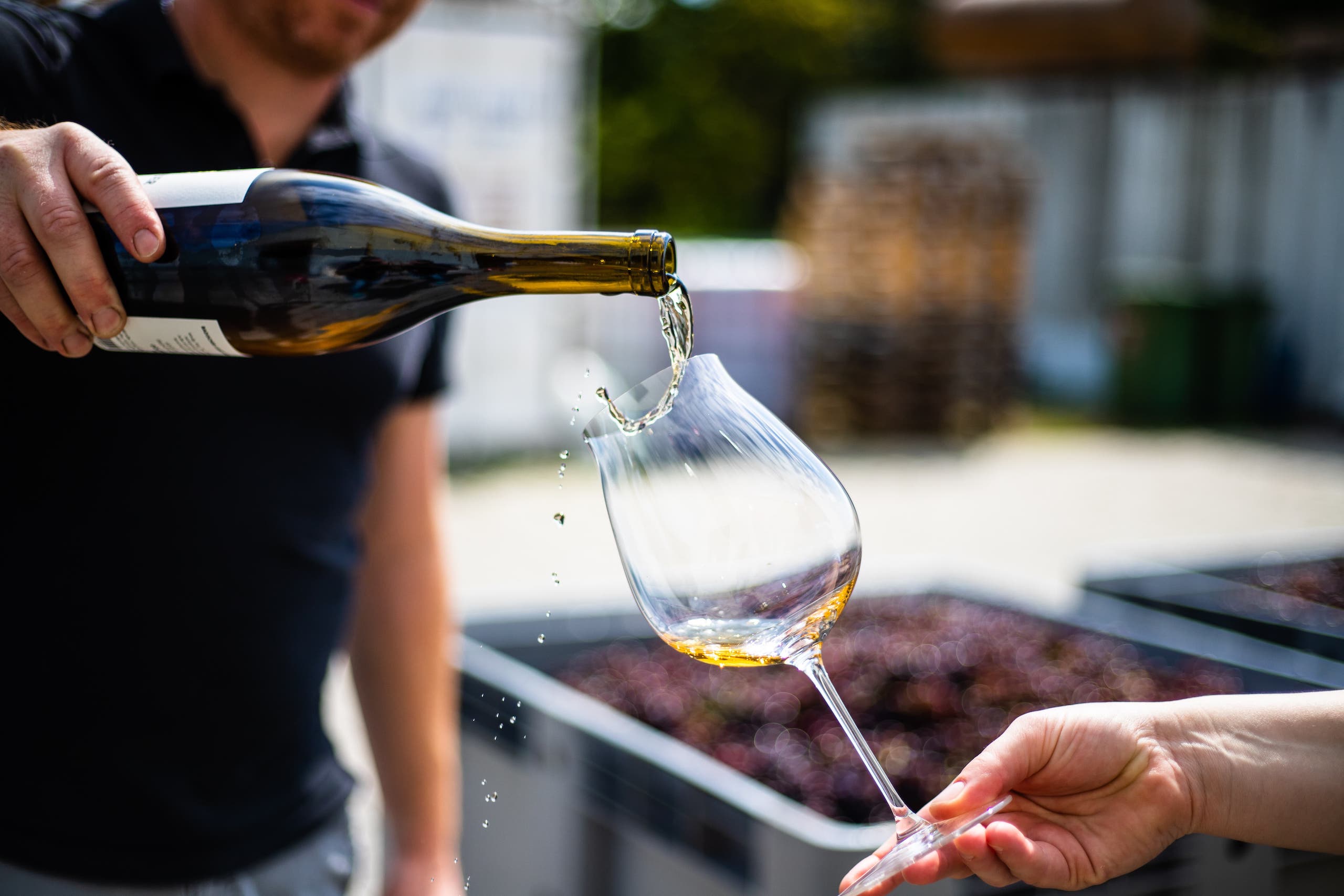 Man spilling wine while trying to pour it