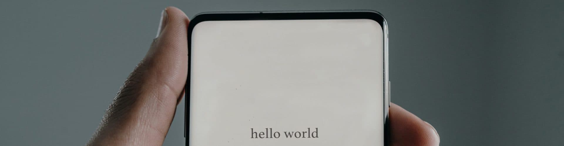 A phone in someone's hand that says hello world