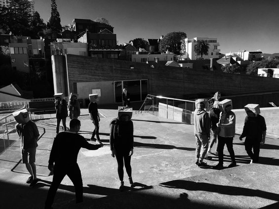Students with bags on head on roof