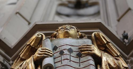 A statue of an angel, holding a music score