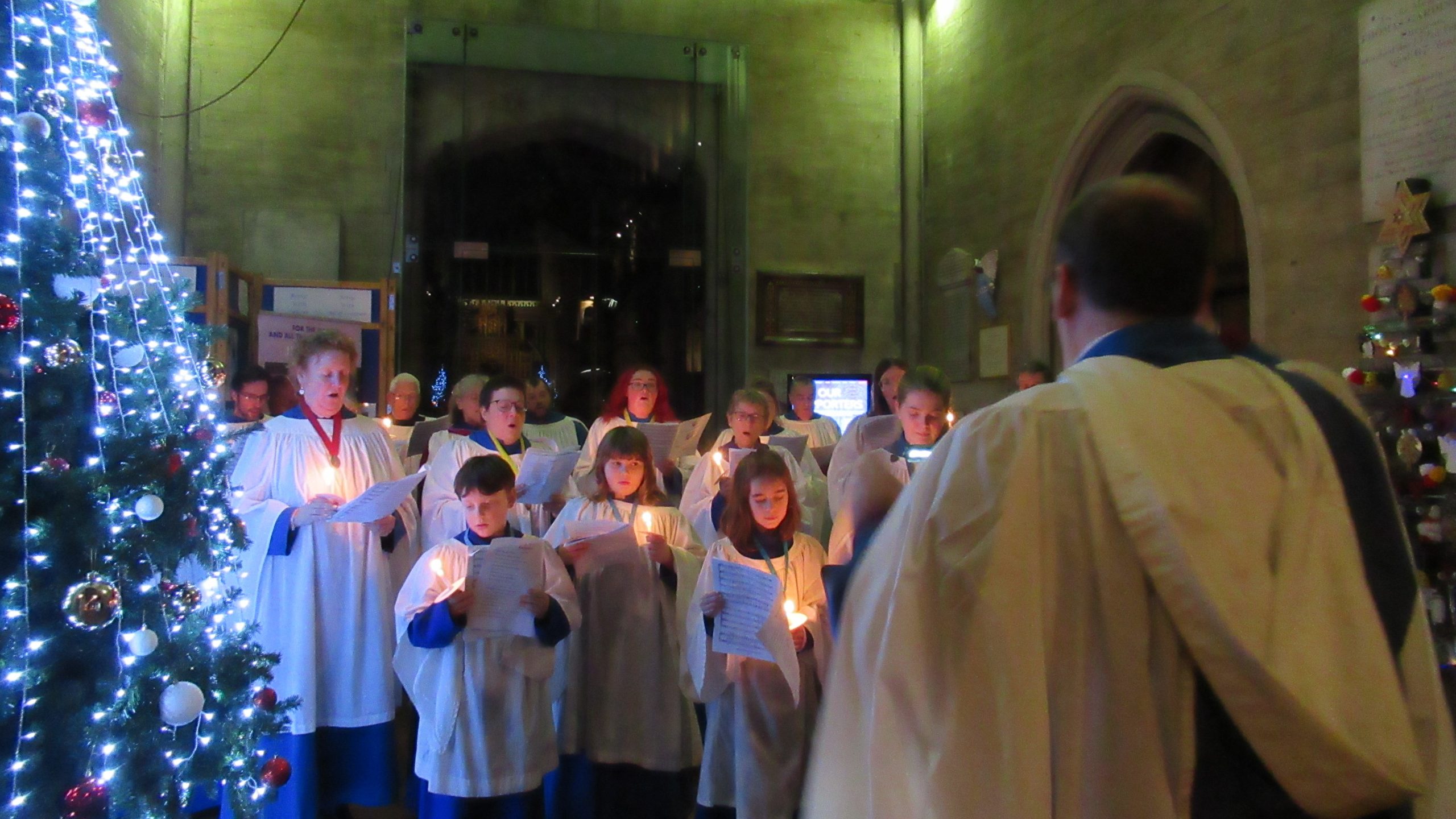 The choir singing at the entrance by candlelight