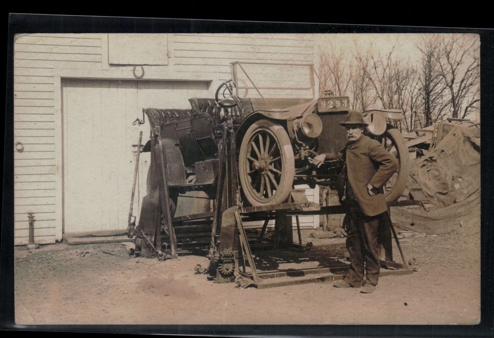 Auto Car Repair On Racks In Front Of Garage Mechanic Posing 1910 Real Photo Postcard