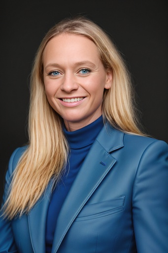 Blonde woman with blue eyes posing in a formal blue suit