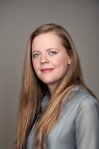 Woman wearing corporate clothing poses for headshot