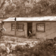 Man reading outside cabin/house. Great Ocean Road. Victoria. c1920s.