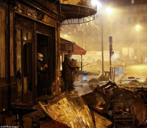 Riot police officers stand in the middle of the damage of La Belle Armee restaurant